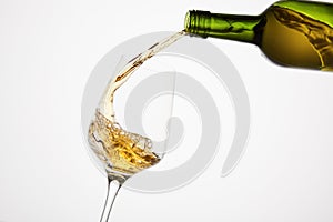 White wine pouring from green bottle, close up shot on white isolated.