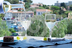 White wine of Provence, France, served cold with soft goat cheese on outdoor terrace in two wine glasses photo
