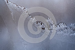 White winter window pane with frosty pattern as background.