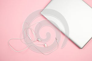 White wired headphones and laptop on pink isolated background. top view. flat lay. mockup
