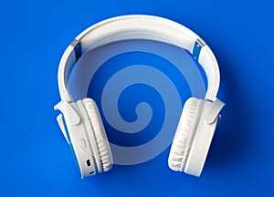 white wireless bluetooth earphones on blue background