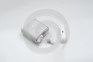 White wireless earphones with charging case isolated on white background. New technology for runners: fitness headphone. Earbuds
