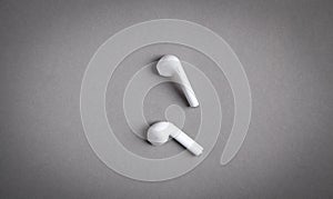 White wireless earphones on the grey background