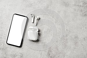 White wireless earphones with smartphone