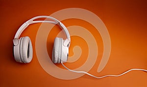 White wireless headphone on orange background