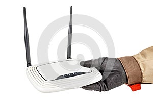 White wireless wi-fi router with two black antennas in electrician hand in protective glove and uniform isolated on white