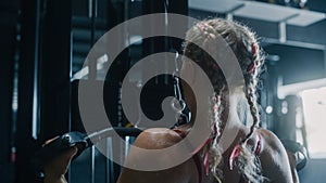 White Woman Doing Extreme Workout in a Hardcore Gym Using Lat Pull Down Machine. Portrait of a