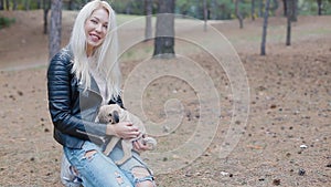 White woman playing with puppy pug outdoors