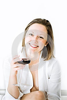 White woman in white shirt drinks red wine