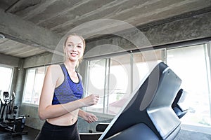 White women are exercising on exercise machines. Young people running on treadmill in gym. Young caucasian exercising on a