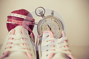 White women& x27;s sneakers, shoes for sports, close-up. Apple and stopwatch. Concept of fitness, sport, healthy lifestyle
