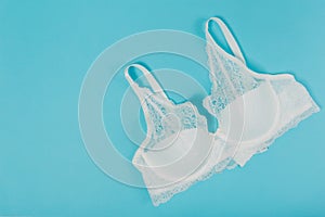 White women underwear with lace on blue background. whitebra and pantie.Copy space. Beauty, fashion blogger concept. Romantic