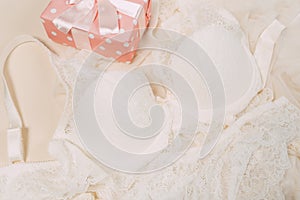 White women underwear with lace and gift box on beige background. white bra and pantie.Copy space. Beauty, fashion blogger concept