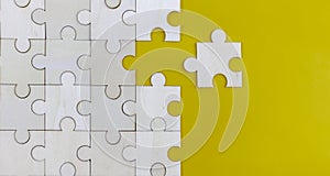 White Wood jigsaw puzzle on yellow background with copy space.