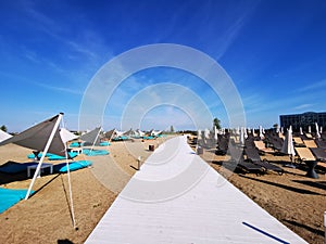 White wooden alley and sunbeds