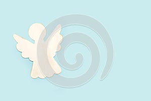 A white wooden angel on a light blue background