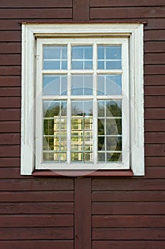 White wooden antique window on a wooden building. Old well-kept wooden house. Old Church and Windows with a cross