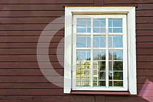 White wooden antique window on a wooden building. Old well-kept wooden house. Old Church and Windows with a cross