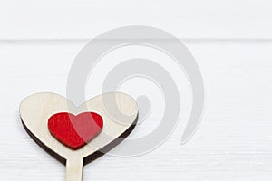Two hearts, red and wooden, on white wooden background. Valentine`s day or Love concept.