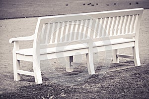 White wooden bench in park - sepia photograph