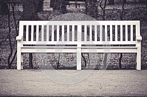 White wooden bench in park - sepia photograph