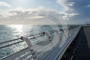 White wooden benches lining a british seaside pier