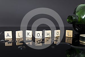 white wooden blocks with individual letters give the word ALKOHOL