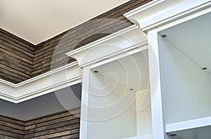 White wooden cabinet crown molding on wooden slats wall background