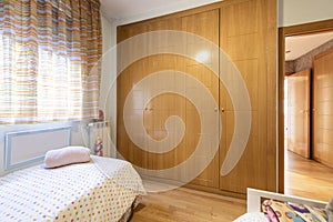 A white wooden cabinet inside a dressing room with many open and closed drawers and doors as well