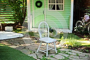 White wooden chair. Cozy terrace in garden with wooden chair. Decor in summer patio for relax. Autumn front porch home. Exterior w