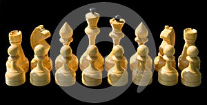 White wooden chess pieces isolated on black