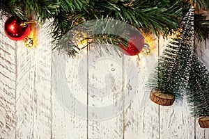 White wooden Christmas background. Empty space for text. Happy New Year. Small Christmas trees, garland with lights