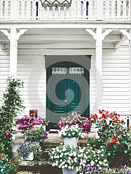 White wooden country house entrance door terrace cozy exterior with flowers