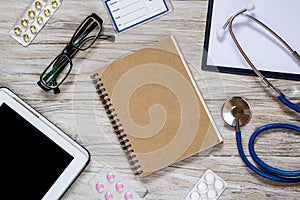 White wooden desktop with office and medical objects on it.