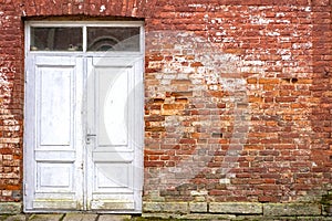 White wooden door at red brick wall