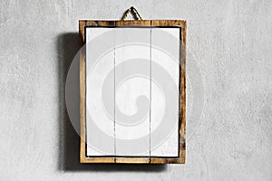 White wooden empty board hanging on gray concrete cement wall