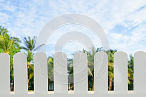 White wooden fence isolated the abstract blur of beach and luxury hotel restaurant background that separates the objects
