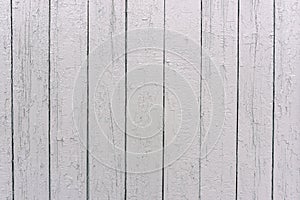 White wooden fence. The surface of the tree. Painted boards in white color. Uneven texture. Wood texture background