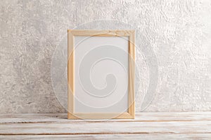 White wooden frame mockup on gray concrete background. Blank, vertical orientation, copy space