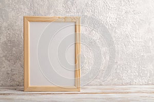 White wooden frame mockup on gray concrete background. Blank, vertical orientation, copy space