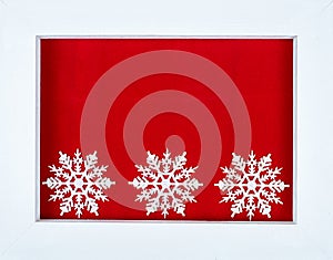 White wooden frame and snowflakes over a red background