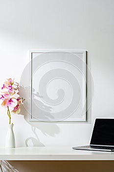 White wooden frame on white wall above the table copy space