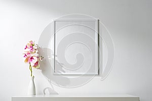 White wooden frame on white wall above the table copy space