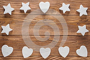 White wooden hearts and stars on brown wooden background, copy space,