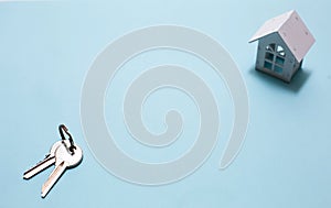 White wooden house symbol and keys on a blue background.