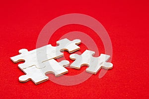 White wooden jigsaw puzzle on a red background For practicing meditation, problem-solving skills, and patience. business &