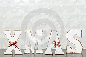 White wooden letters on brown wooden table forming word XMAS wit