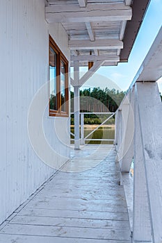 White, wooden lifeguard booth against lake and forest view