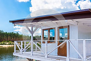 White, wooden lifeguard booth situated on sand beach next to the lake