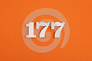 White wooden number 177 on eva rubber orange background